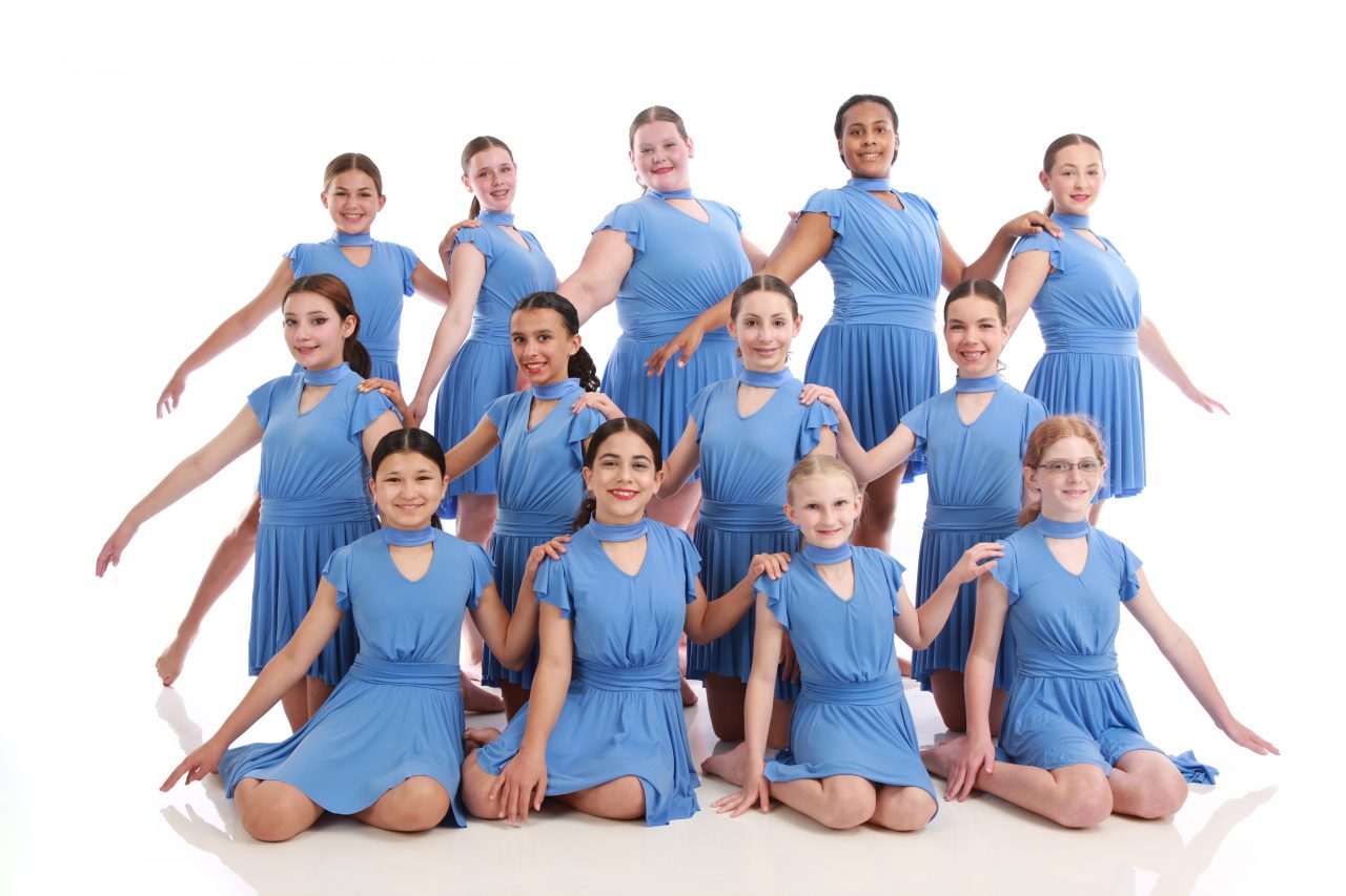 Group of young female dancers in flowing blue dance costumes pose for dance recital photography in Exulting Images’ Fort Mill SC studio