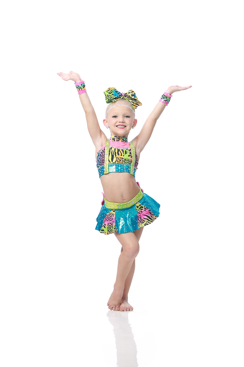 Young female dancer in a multicolored animal print costume poses with arms raised for dance recital photography in Exulting Images’ Fort Mill SC studio