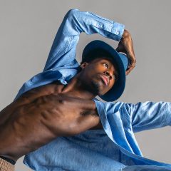 Brown skinned dancer in open blue button up and blue fedora poses for modern dance action shot in Exulting Images' Fort Mill, SC studio