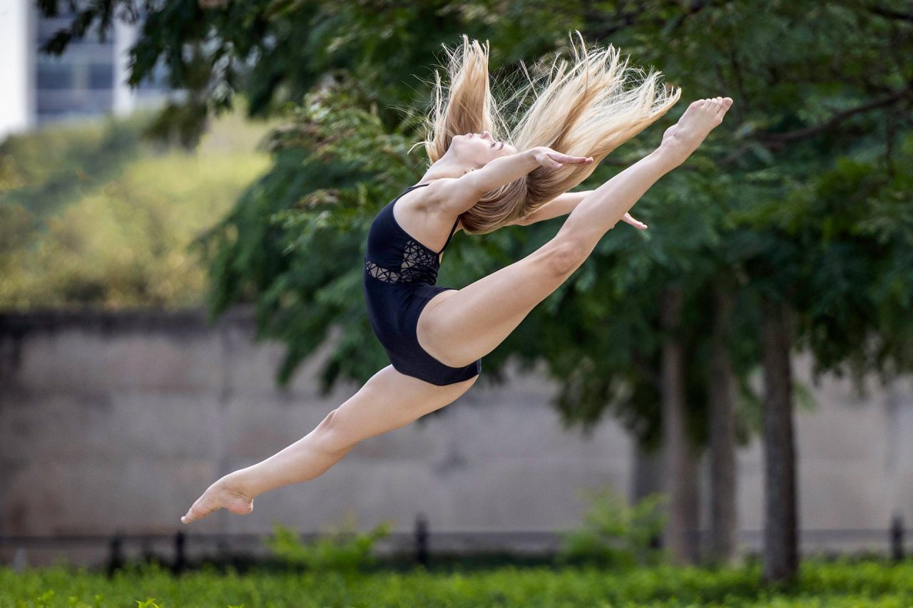 Dancer in navy leotard captured mid-air on dance ring jump during dance photoshoot outdoors with Exulting Images in Charlotte, NC