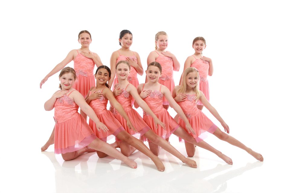 Group of young female dancers in pink dance costumes costumes pose for dance recital photography in Exulting Images’ Fort Mill SC studio