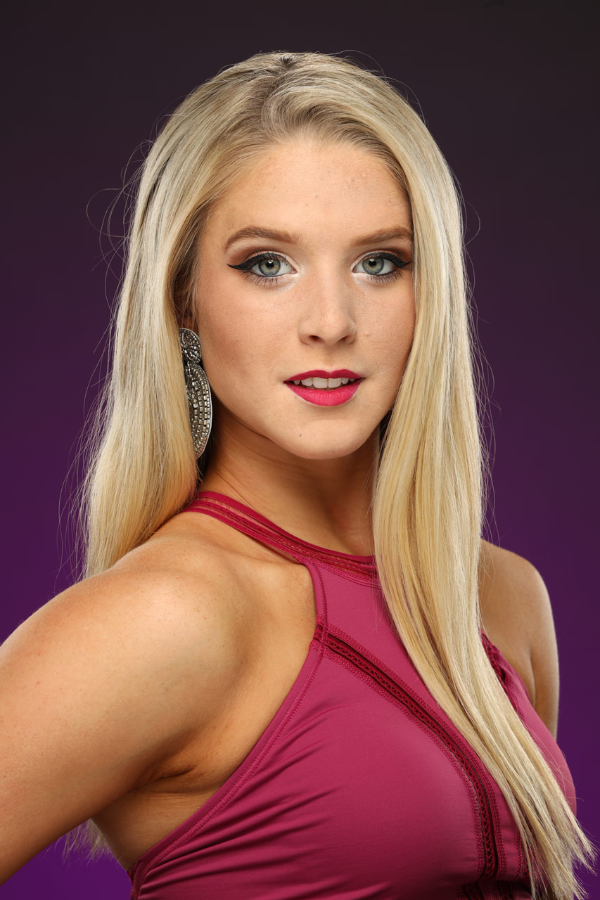 A teenage girl with straight blonde hair wearing a pink halter top and large silver earrings smiles for headshot taken in Exulting Images’ Fort Mill, SC studio