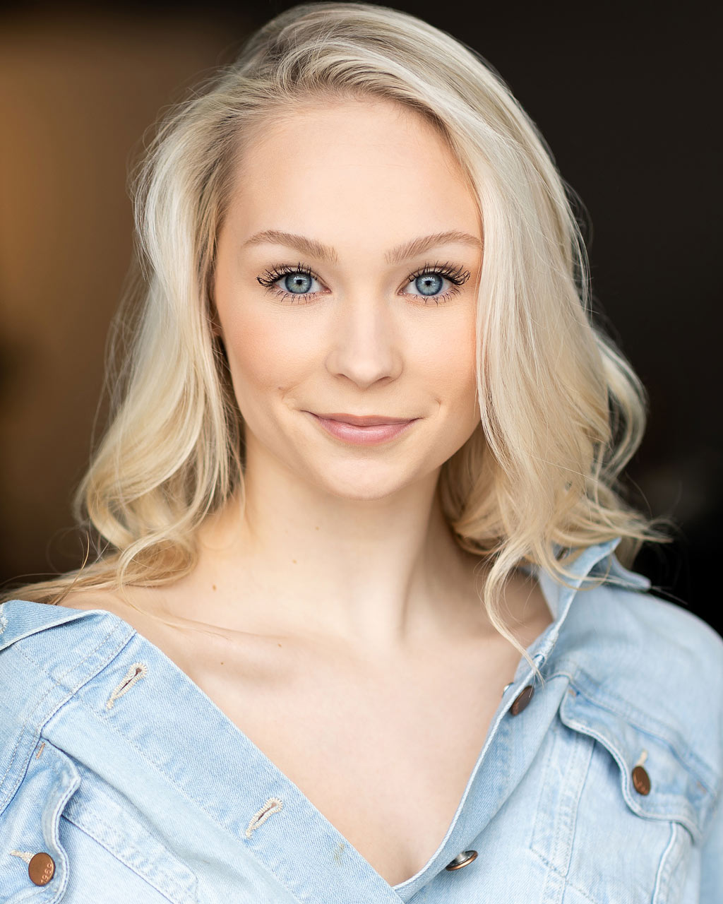 Dancer headshot of bright blue-eyed blond-haired female gently smiling at camera captured by professional headshot photographer Exulting Images