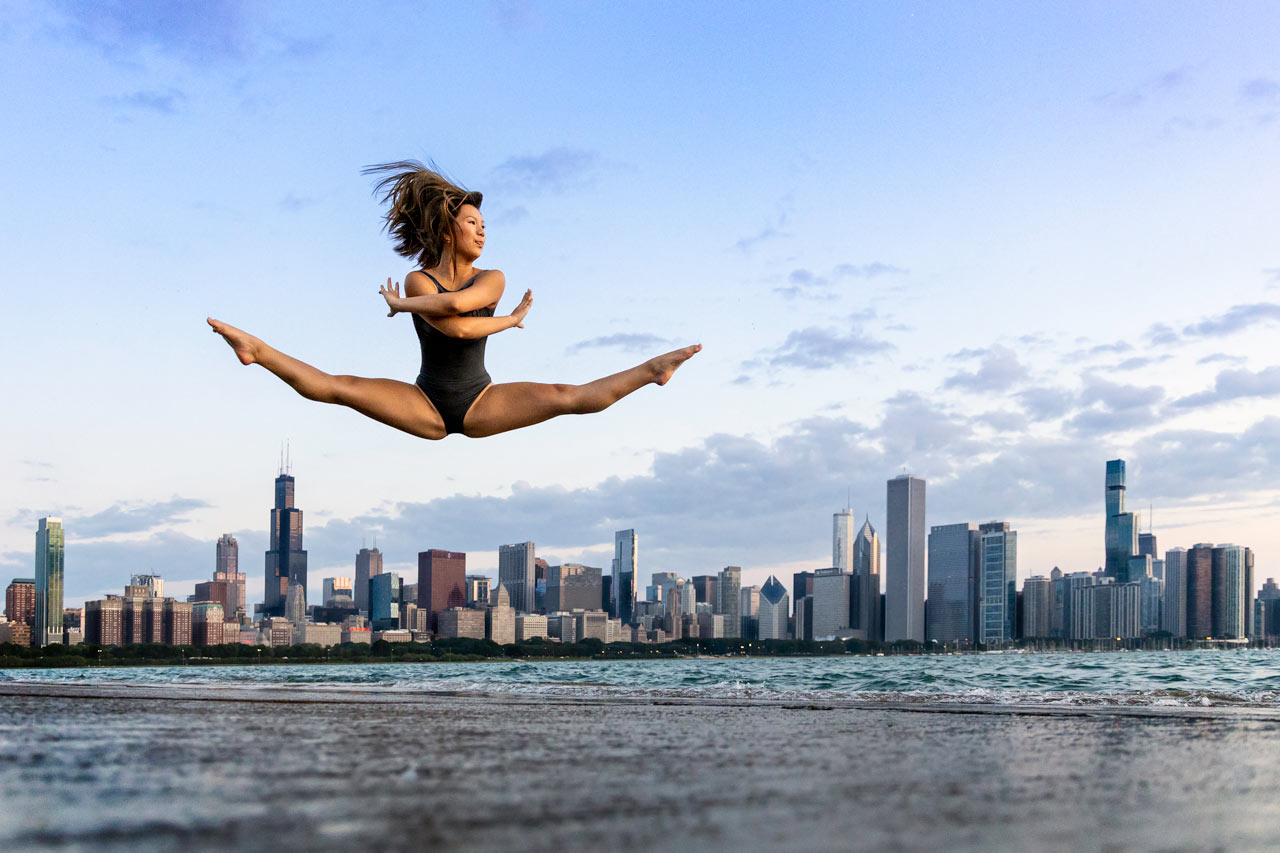 Dancer captured midair in split jump in front of Chicago skyline for Exulting Images outdoor dance photoshoot