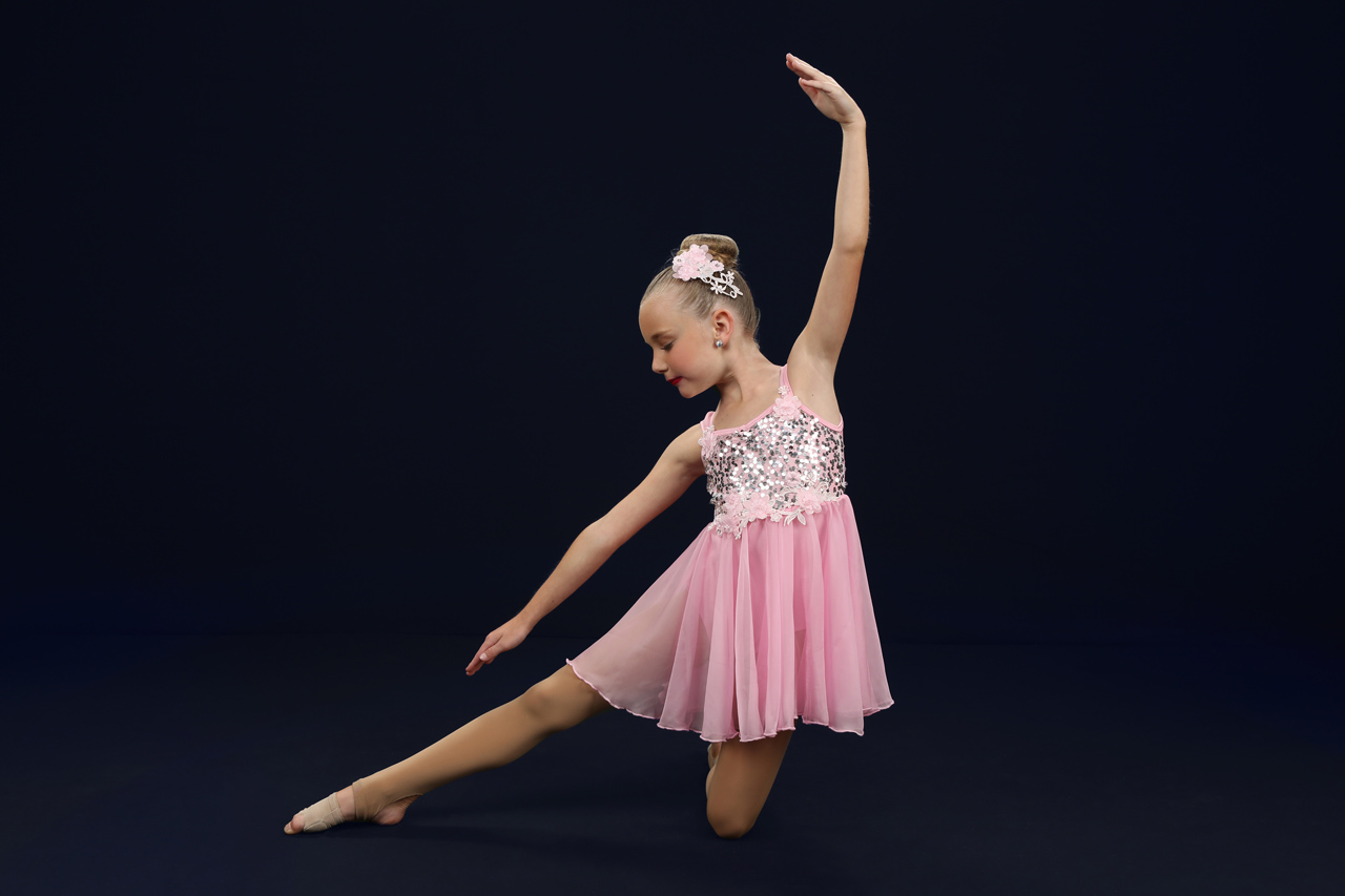 Young Charlotte, NC female dancer in light pink sequined dance costume poses for Exulting Images' dance recital photography