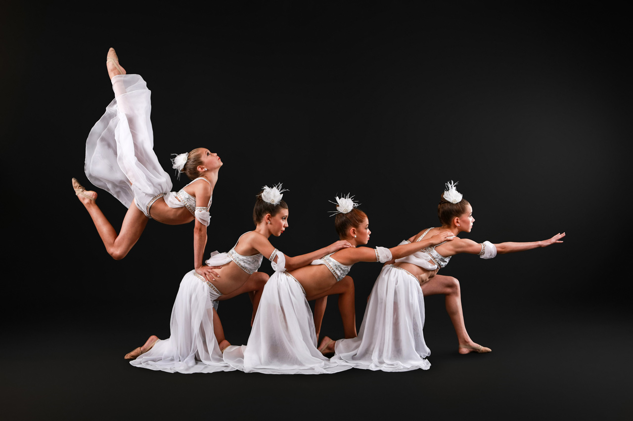 Exulting Images’ dance recital photography of four young girls in white flowing costumes
