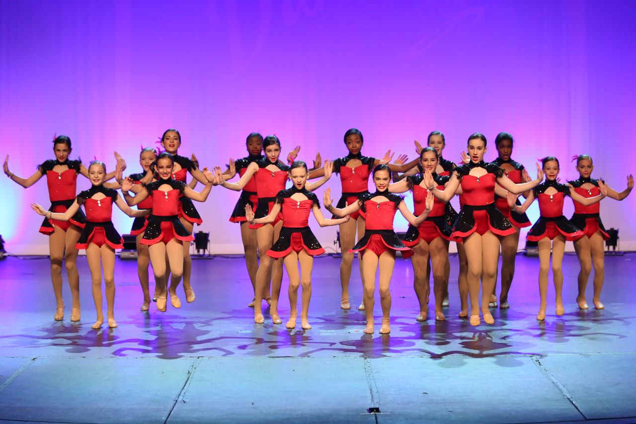 Exulting Images’ dance recital photography with dancers in red and black costumes performing on stage