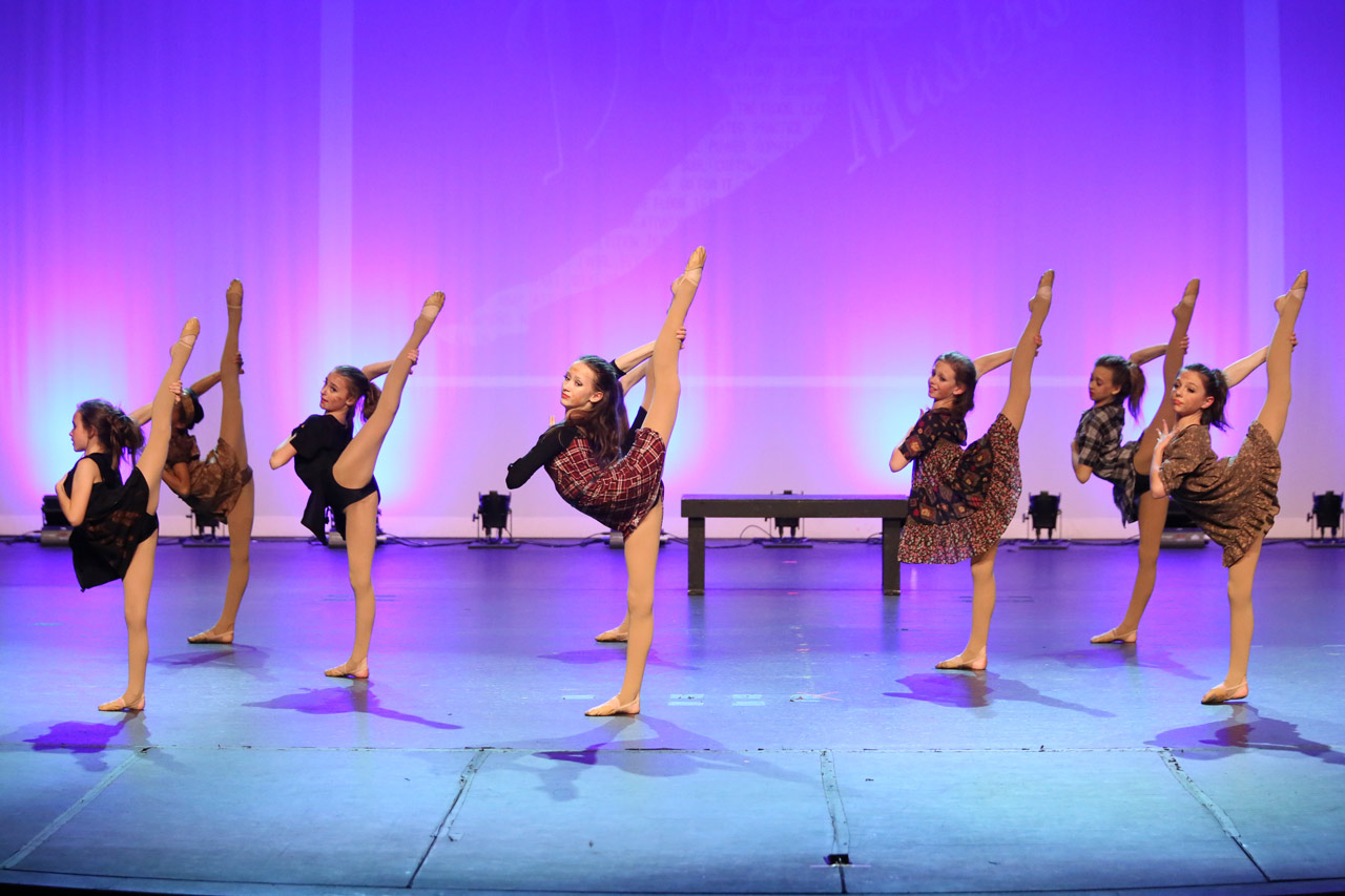 Exulting Images’ modern dance action shot of teen dancers balanced on one leg with other raised gracefully behind them during dance recital