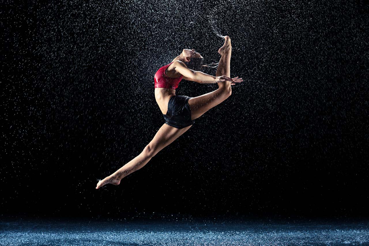 Modern dance action shot of leaping female dancer for Exulting Images’ dance photography with rain