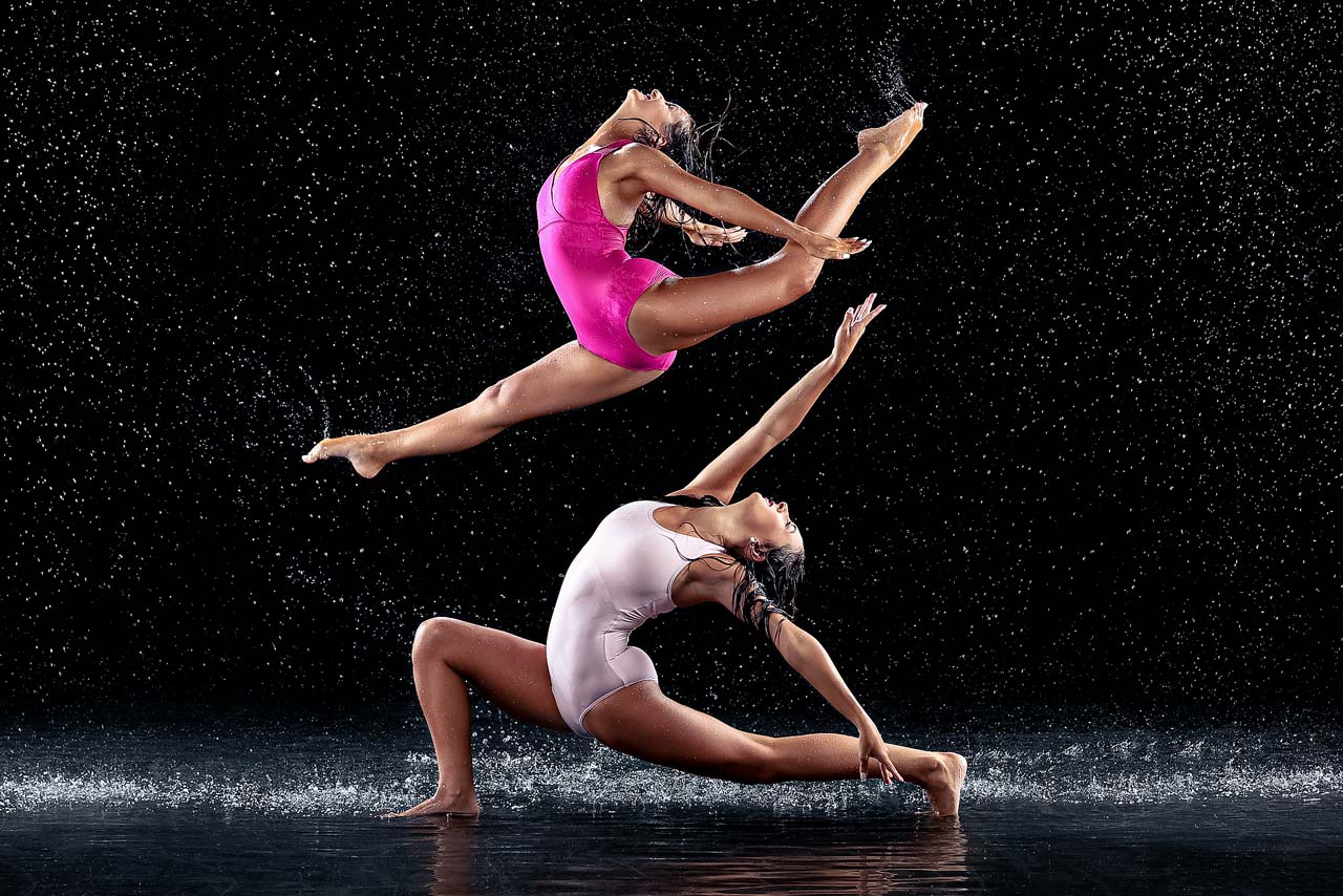 Exulting Images dance photography with rain of two females one leaping and one lunging on the ground